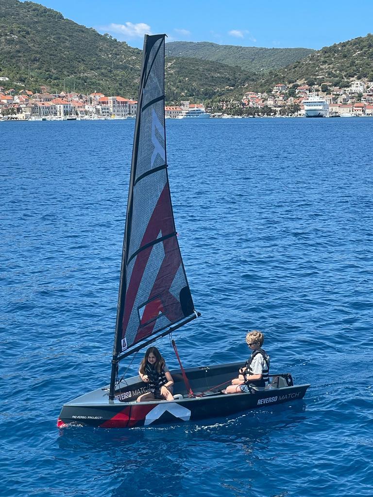 Sailing school students aboard a small sailboat on the Mediterranean